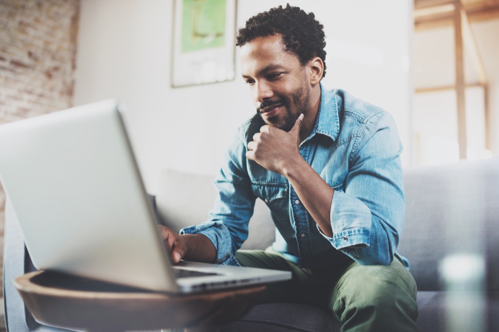 man smiling at laptop long-distance relationships